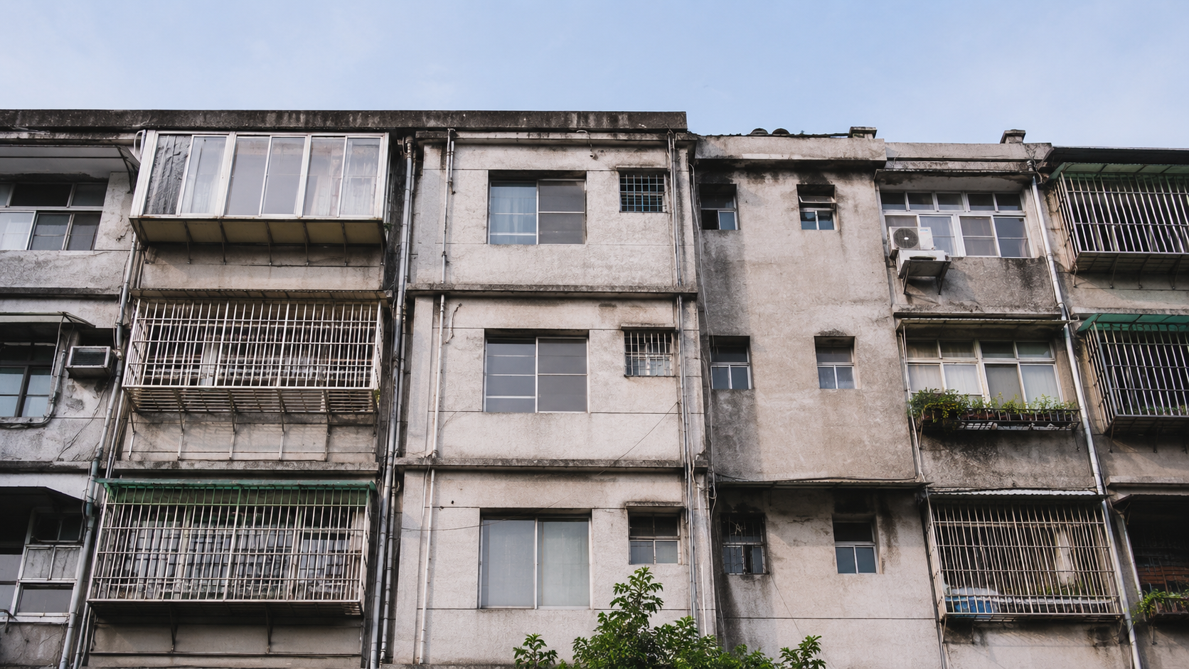 台灣老公寓外觀與公共空間照片，可見外牆、窗框、外部管線與樓梯間老化狀況，呈現尋找專業廠商協助評估翻新順序的情境。